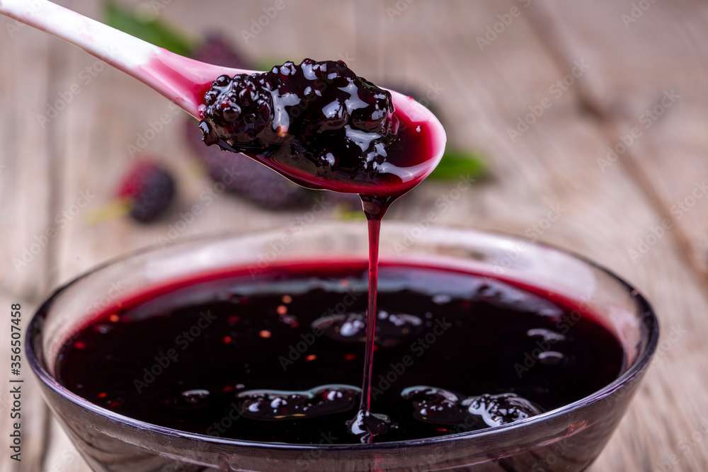 Domestic fresh mulberry jam on a rustic wooden board